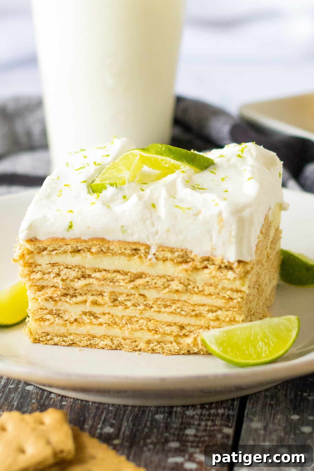 Key lime icebox cake with layers of graham crackers and key lime custard topped with homemade whipped cream and a lime garnish.