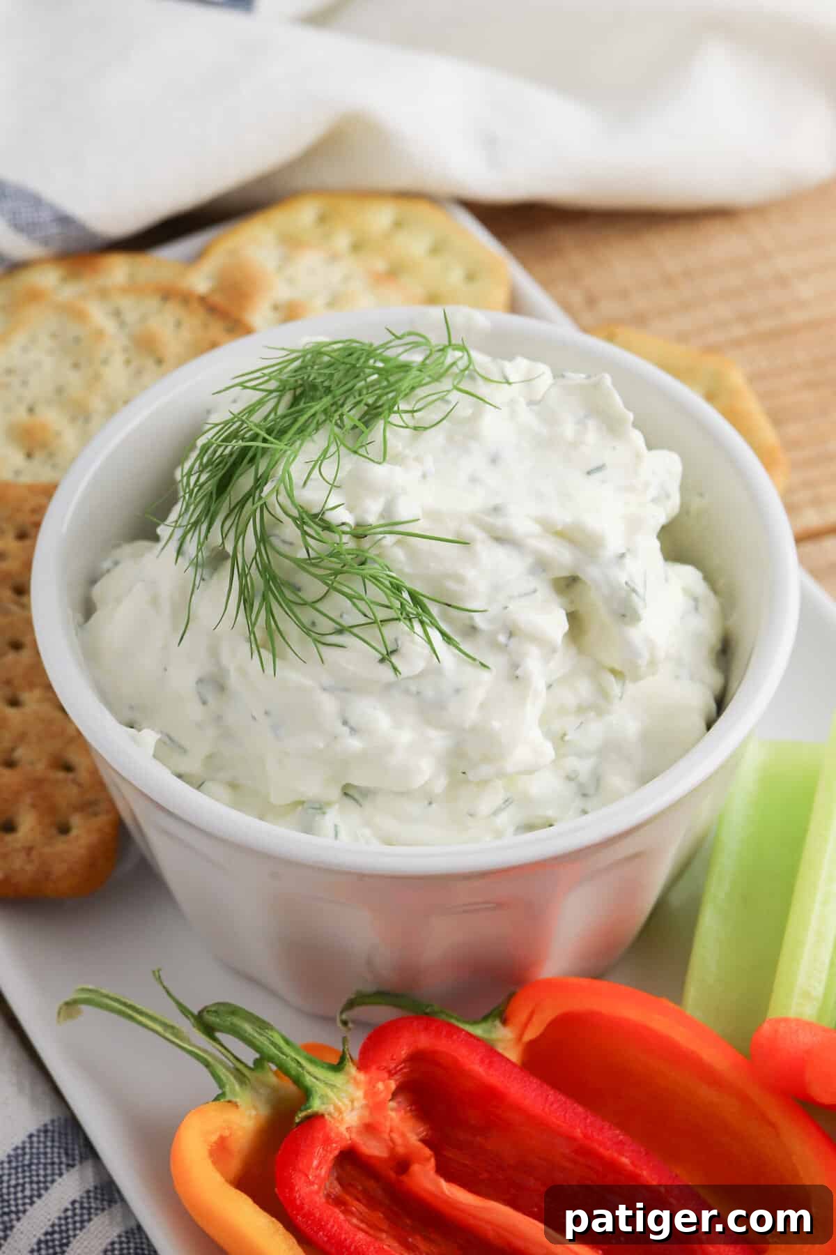 Zesty Dill Cream Cheese Dip 2 Cream cheese dill dip garnished with fresh dill sprig and served with crackers and fresh peppers and celery for dipping.