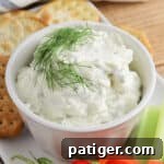 Zesty Dill Cream Cheese Dip 9 Cream cheese dill dip garnished with fresh dill sprig and served with veggie sticks and crackers for dipping.