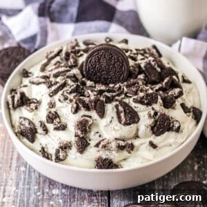 Oreo fluff dessert made with vanilla pudding, cool whip, oreo cookies, and milk.