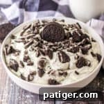 Oreo fluff dessert made with vanilla pudding, cool whip, oreo cookies, and milk.
