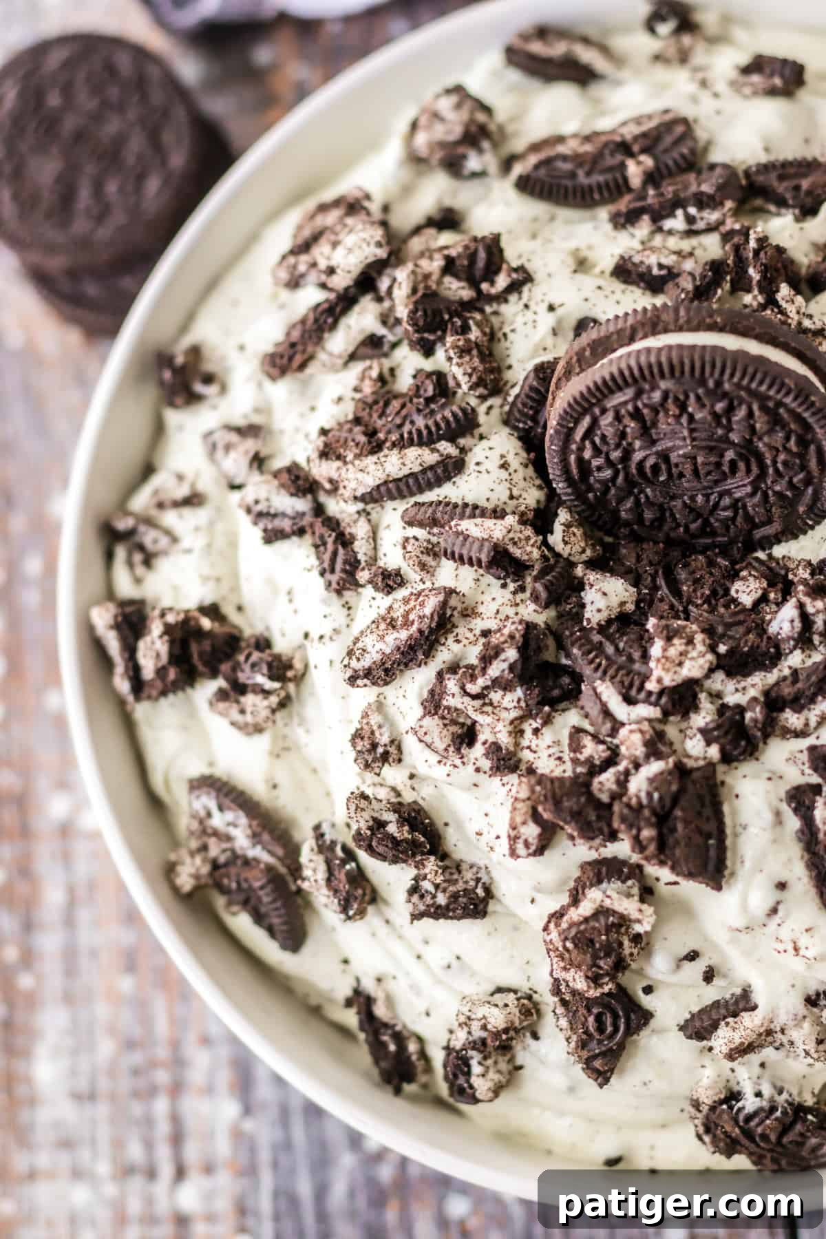 Creamy Oreo fluff dessert topped with extra crushed Oreo pieces in a glass bowl.