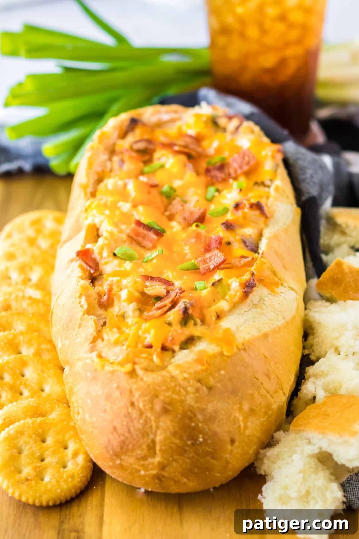 Mississippi sin dip with bacon baked in a french bread loaf and served with ritz crackers and bread pieces for dipping.