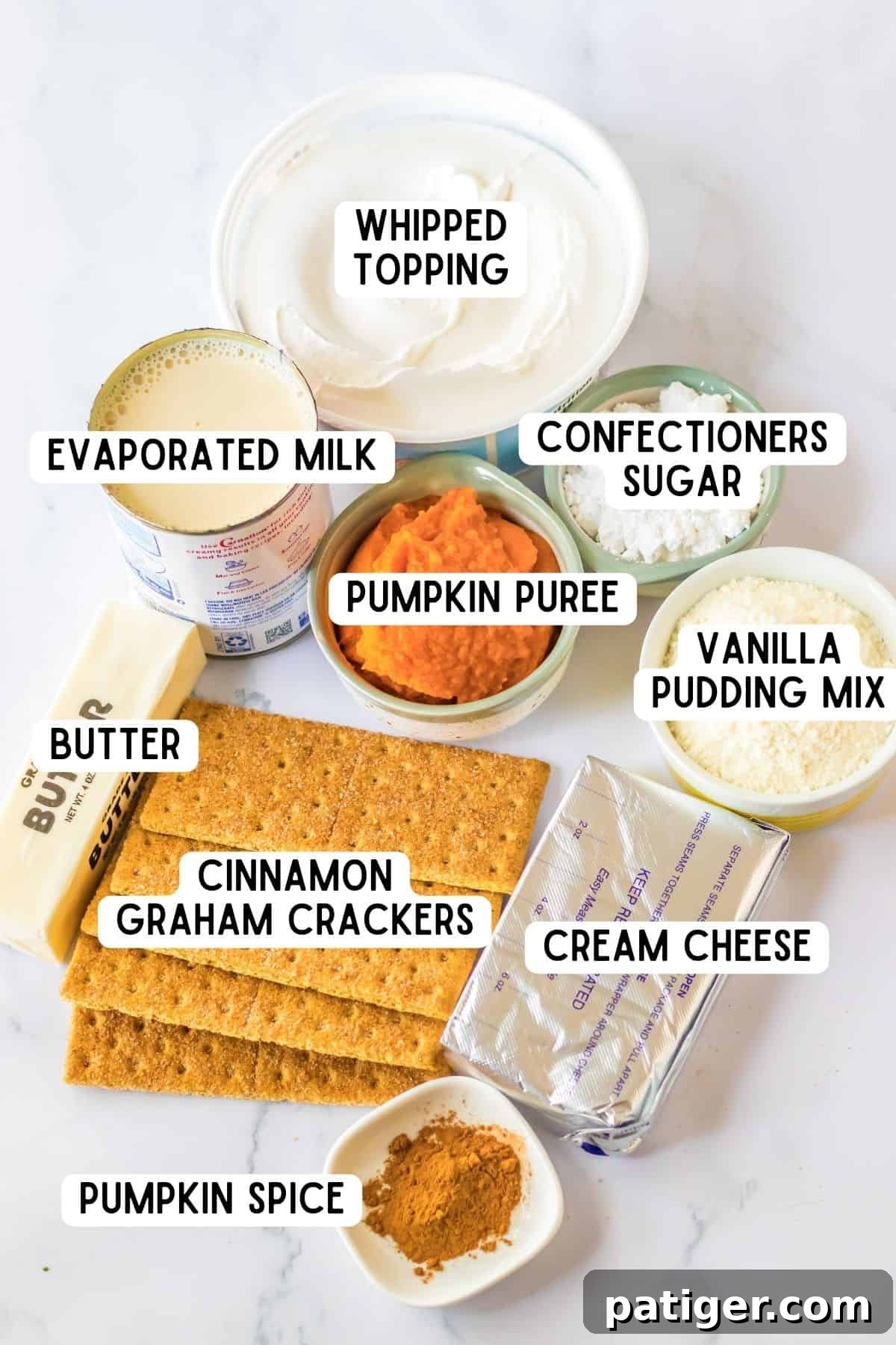A collection of ingredients for Pumpkin Lush: whipped topping, confectioners sugar, evaporated milk, pumpkin puree, vanilla pudding mix, cream cheese, butter, pumpkin spice, and cinnamon graham crackers.