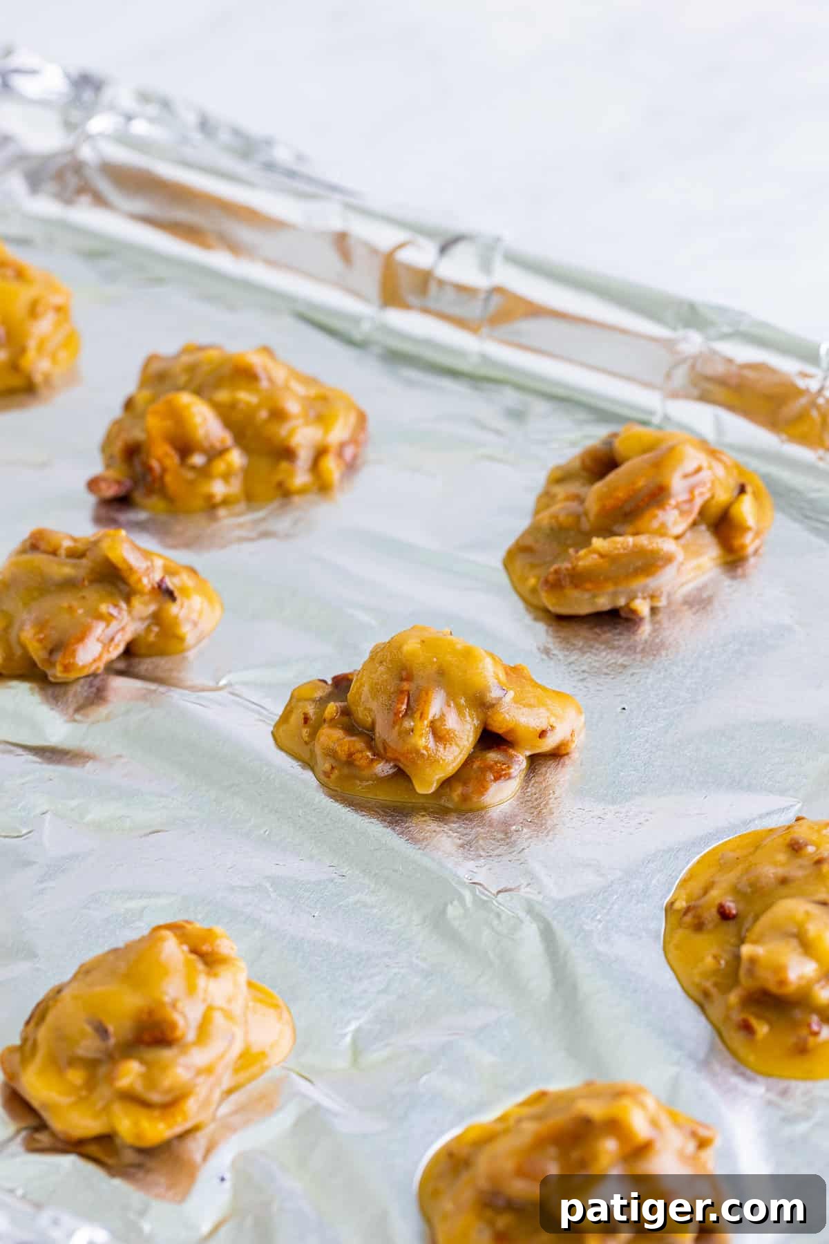 Praline Pecan candies on foil lined baking sheet.