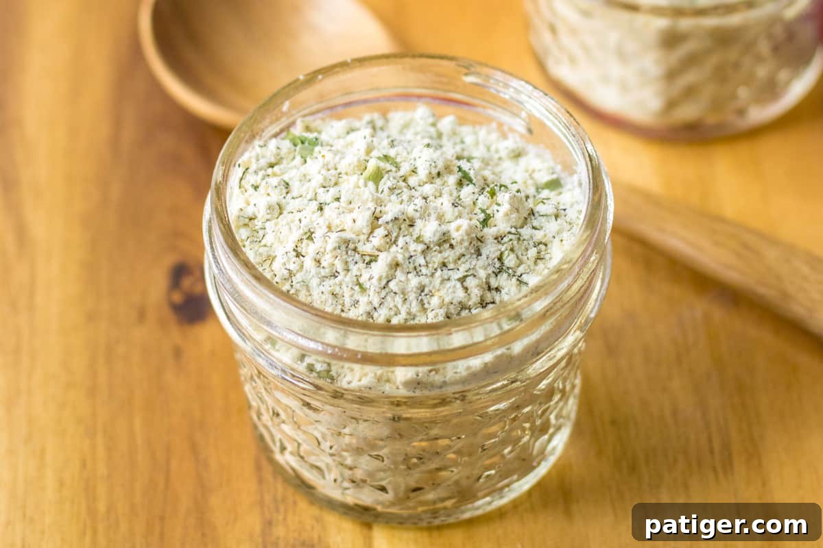 Delicious Homemade Ranch Seasoning 6 A beautiful shot of homemade ranch seasoning, featuring buttermilk powder and a blend of dried herbs and spices, presented elegantly in a clear glass jar.