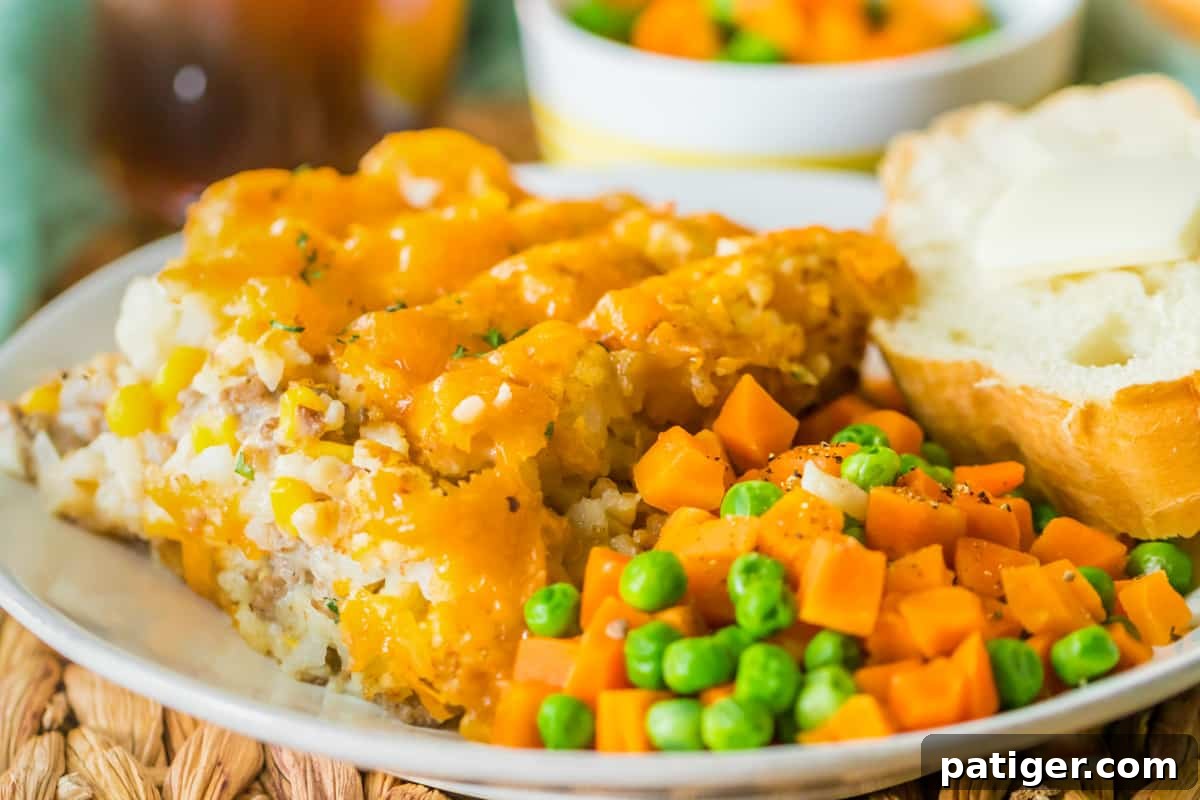 Plated portion of crock pot tater tot hot dish with veggies and buttered bread.