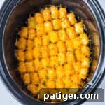 Slow cooker tater tot casserole with melted cheese and ground beef.