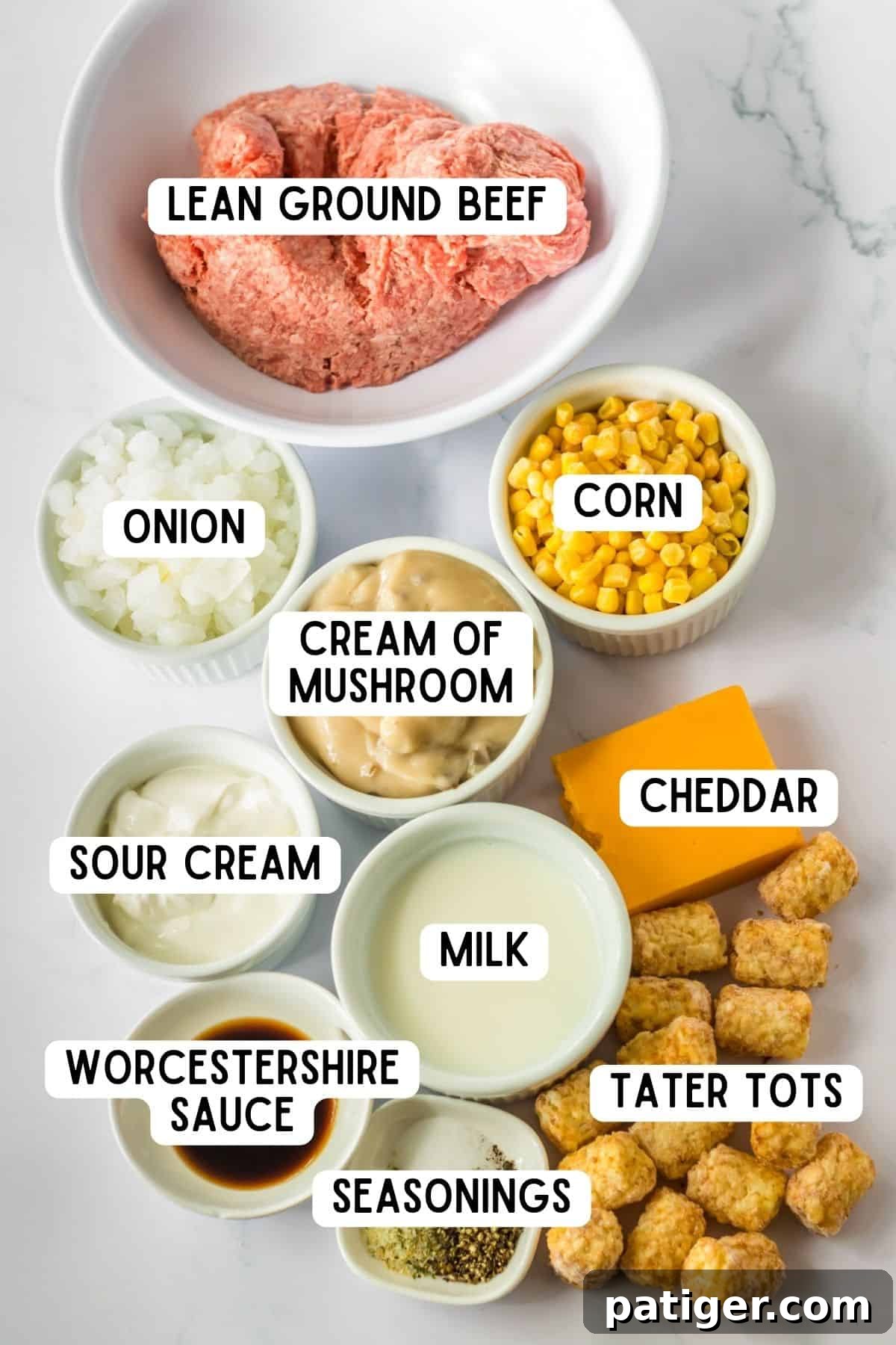 Ingredients for crock pot tater tot casserole:  lean ground beef, corn, onion, cream of mushroom, cheddar, sour cream, milk, worcestershire sauce, tater tots, and seasonings.