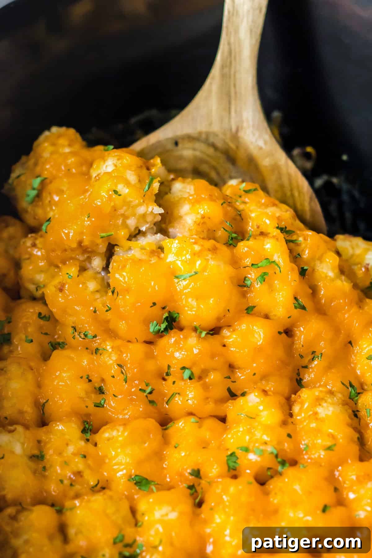 Wooden spoon in slow cooker tater tot casseorle.