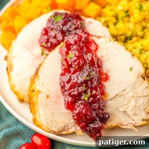 Tender Slow Cooker Boneless Turkey Breast 7 Sliced crock pot turkey roast with cranberry sauce, showcasing the juicy meat and rich glaze.