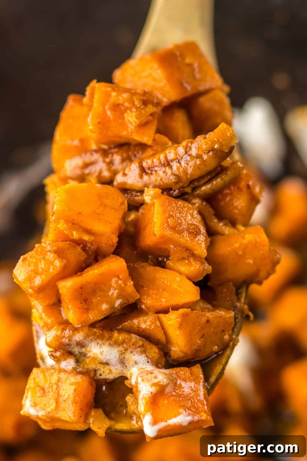 Slow Cooker Sweet Potato Bliss 8 Wooden spoon scooping a serving of the sweet potato side dish out of the slow cooker, showing the rich texture.