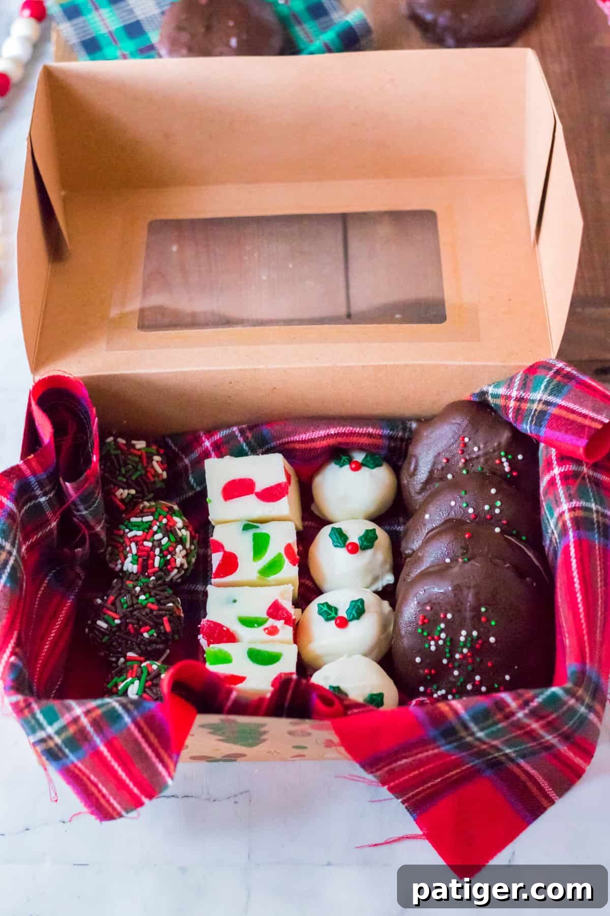 Dozens of Irresistible Christmas Candy Recipes 4 Beautifully presented box of assorted homemade Christmas candy, perfect for gifting. Contents include chocolate rum balls, colorful gumdrop fudge, spiced gingerbread truffles, and classic homemade peppermint patties.