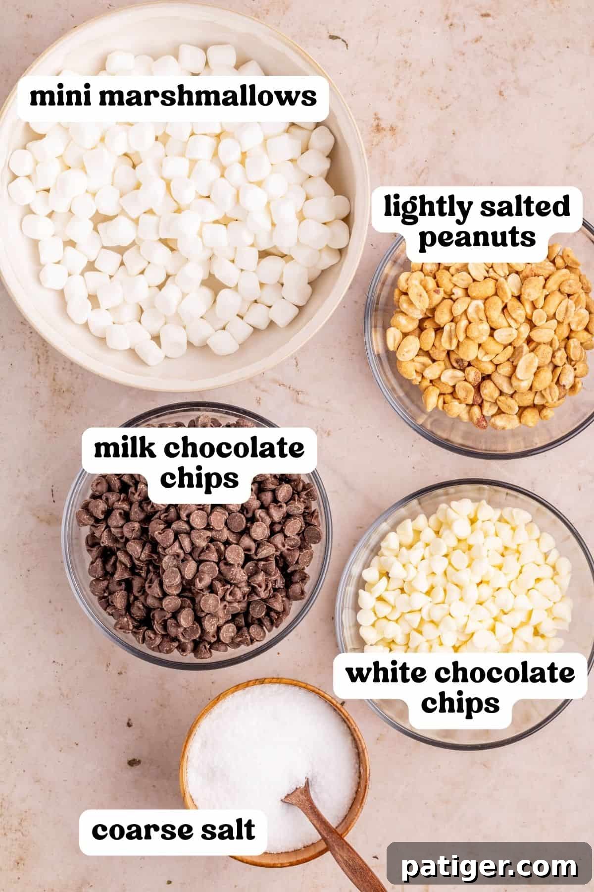 Mini marshmallows, lightly salted peanuts, milk chocolate chips, white chocolate chips, and coarse salt in bowls.