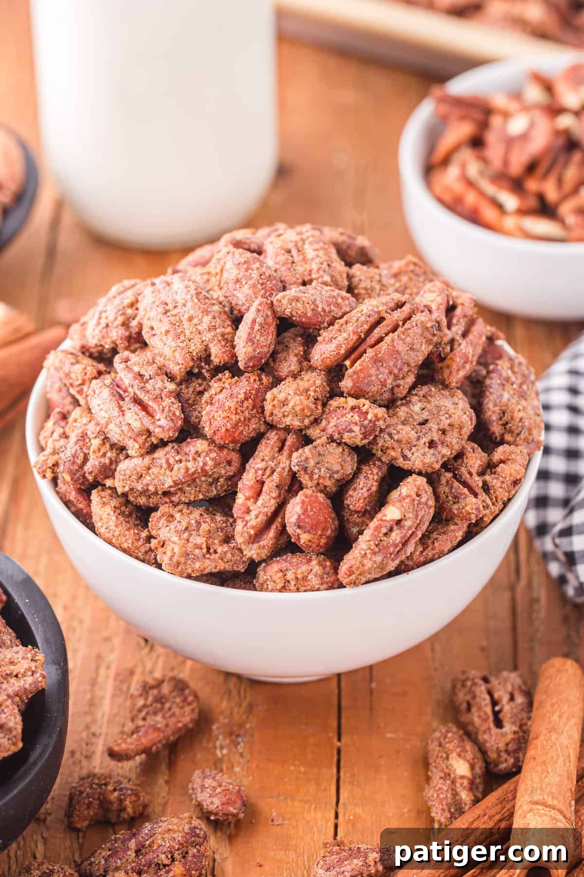Candied pecans and almonds in a white bowl, glistening with sugar.