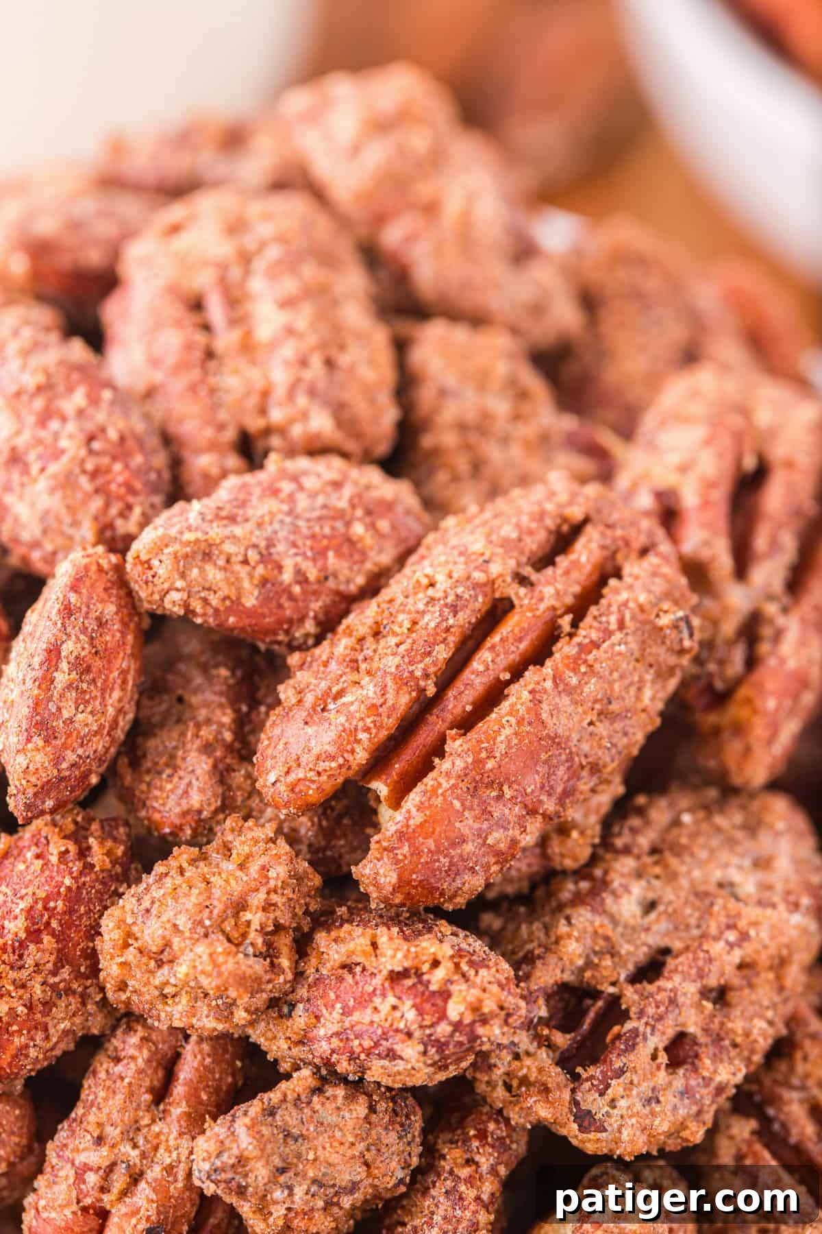 Close up of sweet and crunchy candy pecans and almonds, showing the crystallized sugar coating.