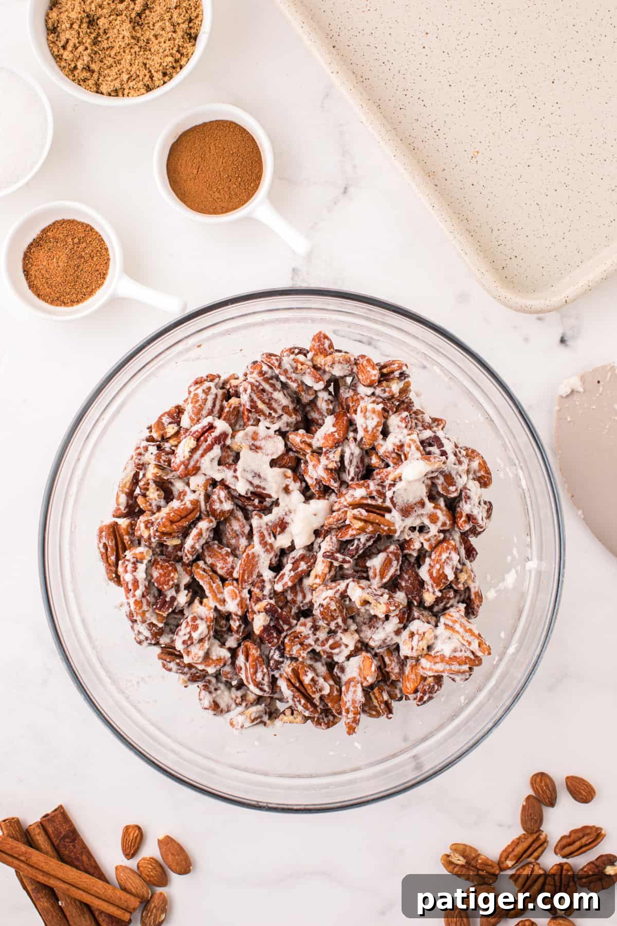 Nuts evenly coated in whipped egg whites, ready for the sugar mixture.