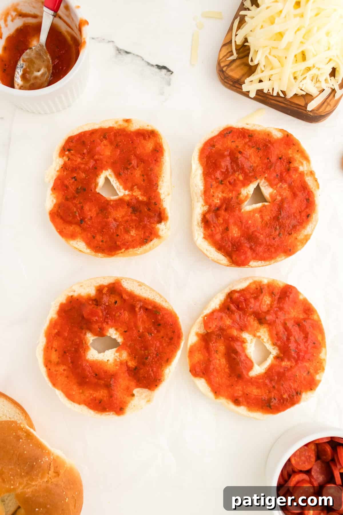 Bagel halves with 1-2 Tablespoons of sauce spread on them.