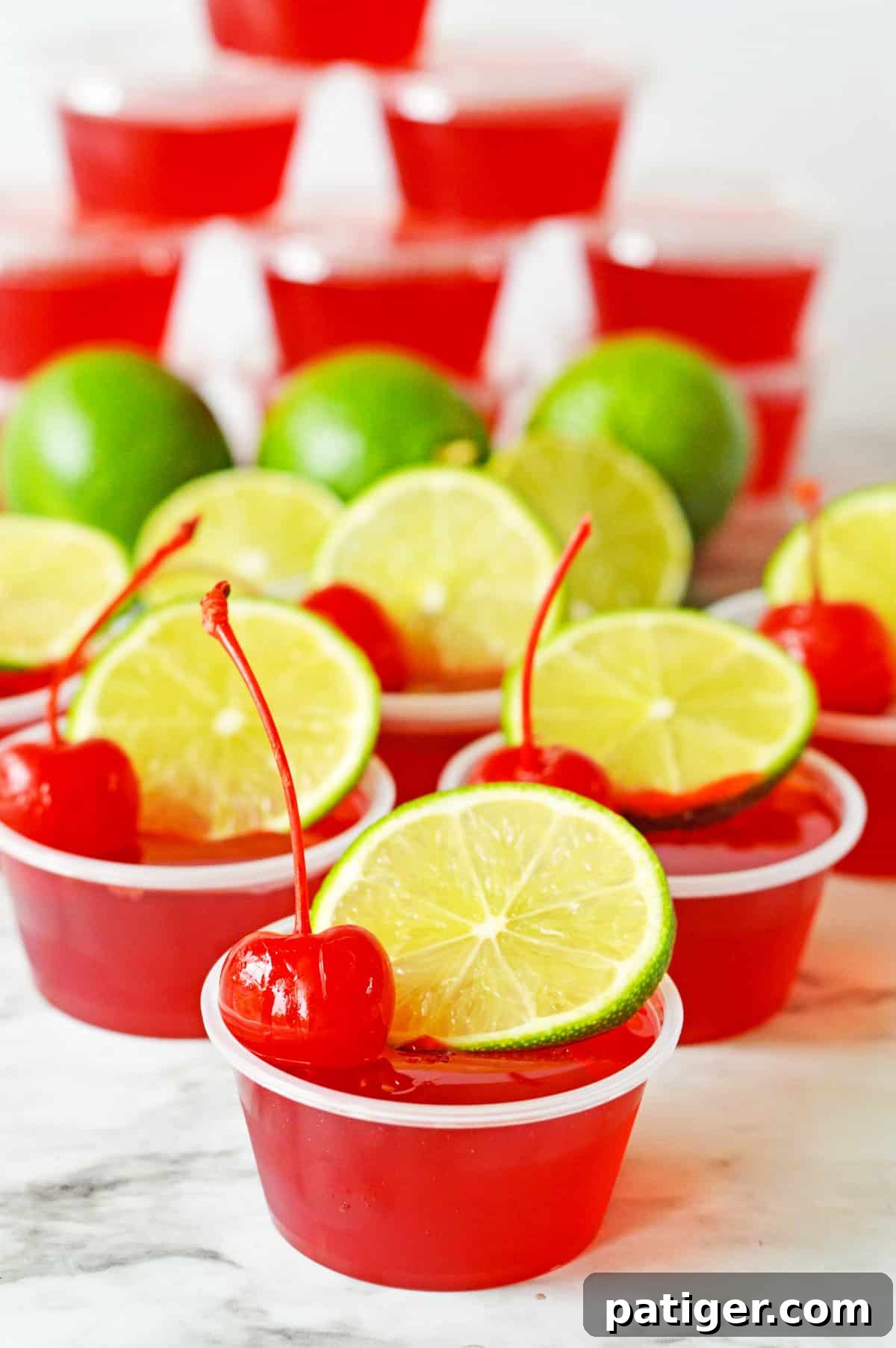 Cherry limeade jello shots topped with fresh lime wheel and maraschino cherry.