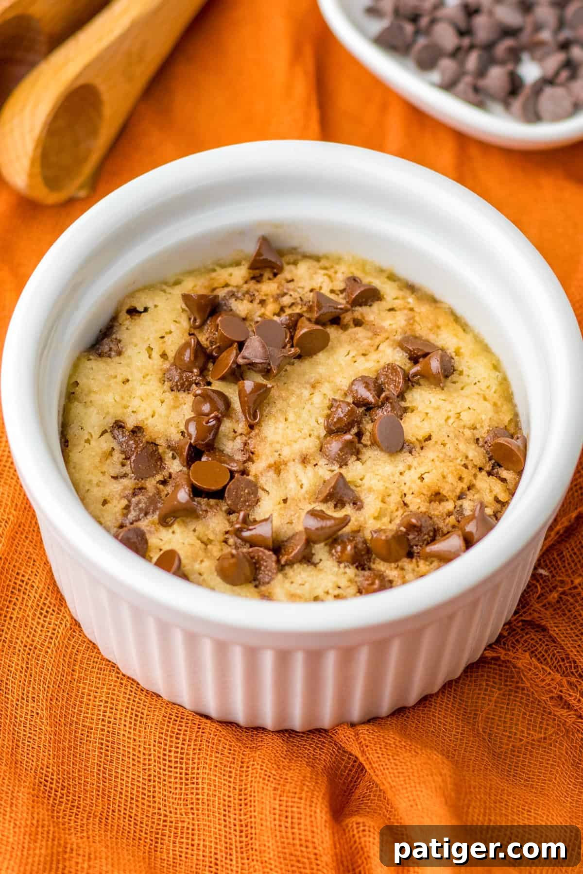 Microwave Chocolate Chip Cookie in ramekin with melty chocolate chips, ready to be enjoyed.