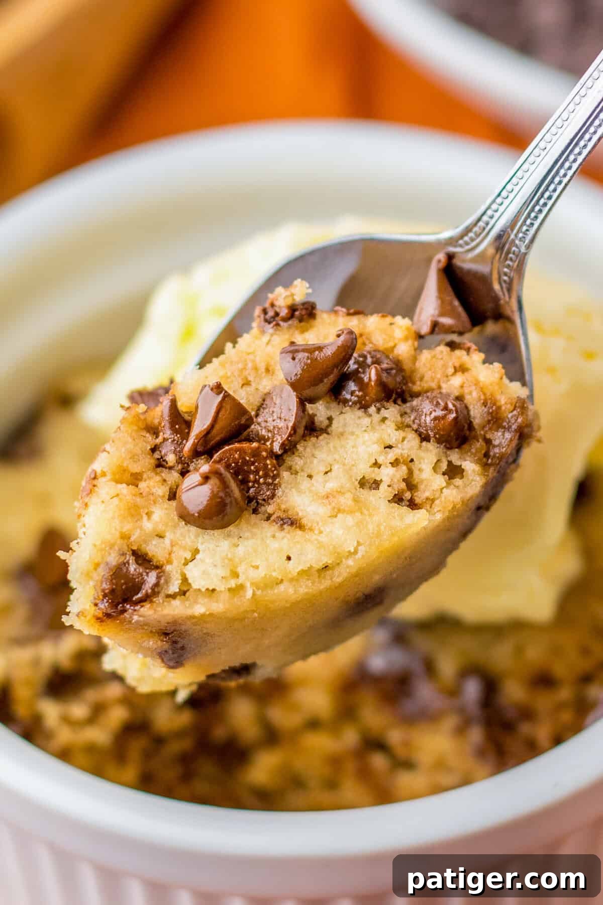 Spoonful of soft chocolate chip cookie mug cake, showing its gooey texture.