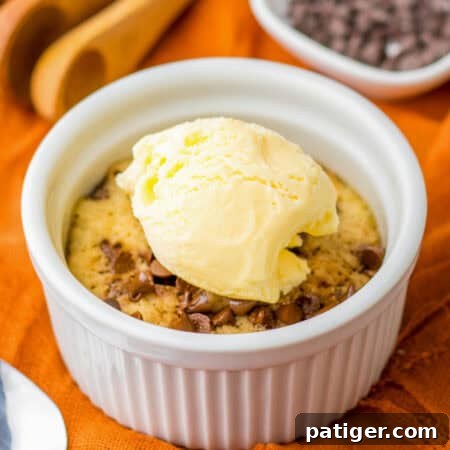 Microwave Chocolate Chip Cookie in a ramekin topped with vanilla ice cream.