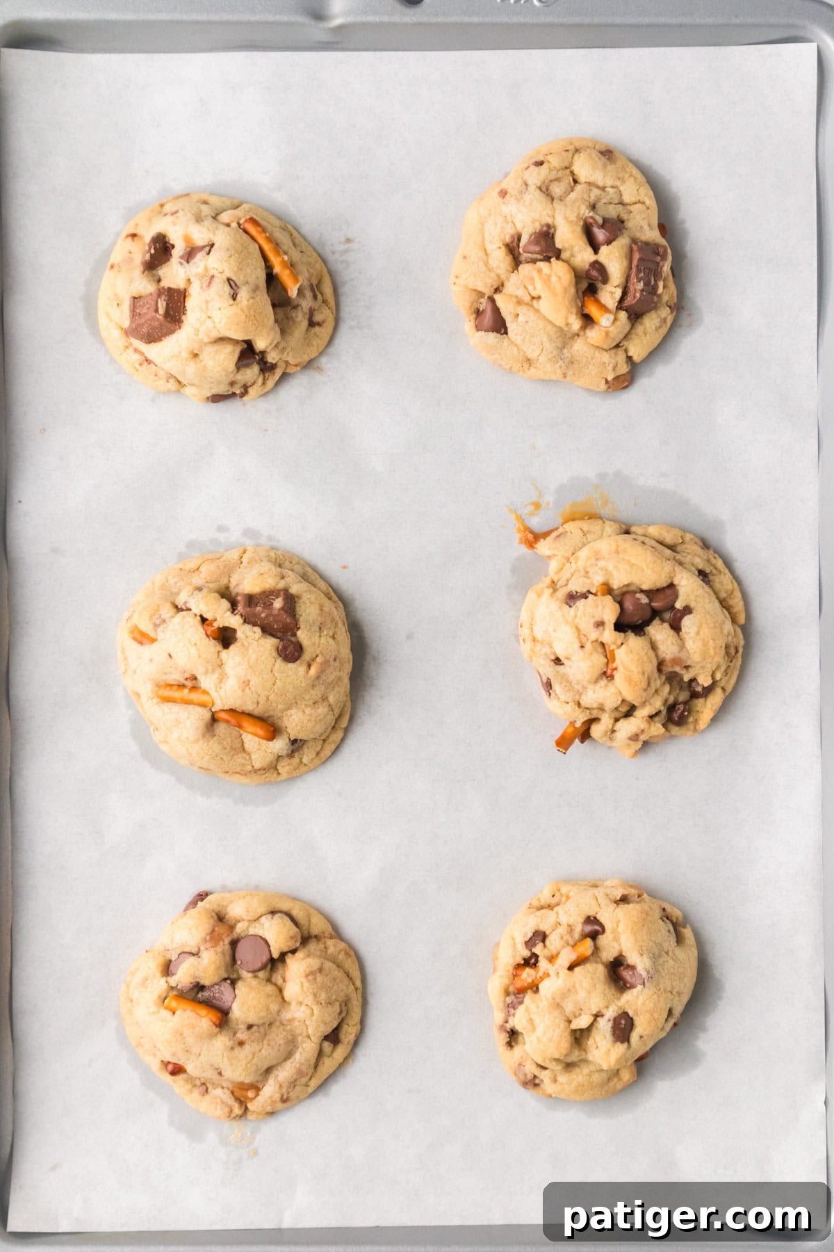 Mega Mix Cookies 9 Homemade kitchen sink cookies with chocolate chunks and pretzels on lined cookie sheet.