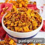 Firecracker spicy chex mix with pretzels, crackers, nuts, coated in a spicy ranch seasoning mix.