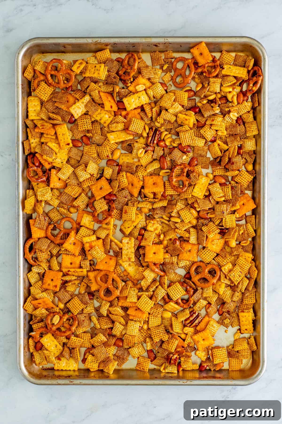 Blazin' Snack Fusion 7 Chex mix spread in an even layer on a baking sheet.