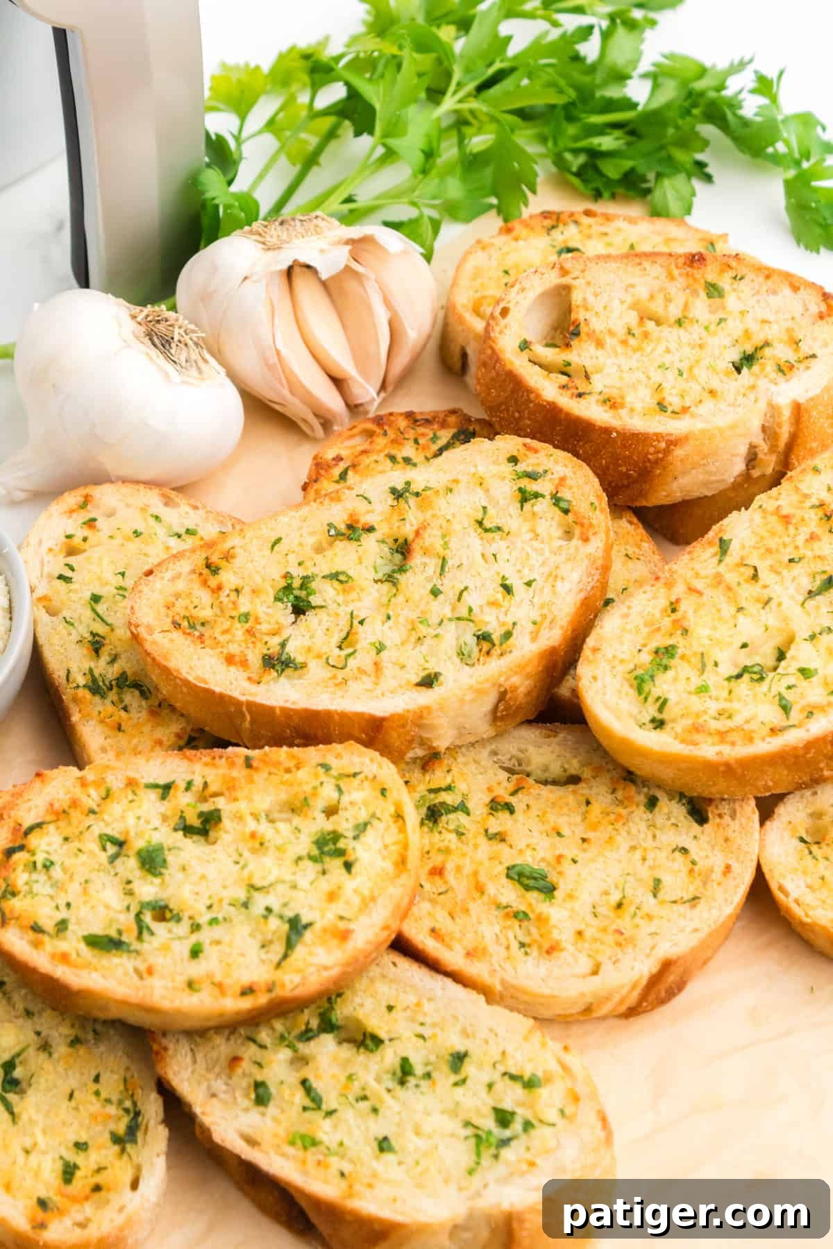 Golden Garlic Bread in Minutes 2 Thick slices of air fryer garlic bread with garlic, butter, Parmesan cheese, and parsley garnish.