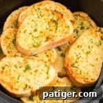 Golden Garlic Bread in Minutes 12 Slices of thick garlic bread stacked in air fryer basket.
