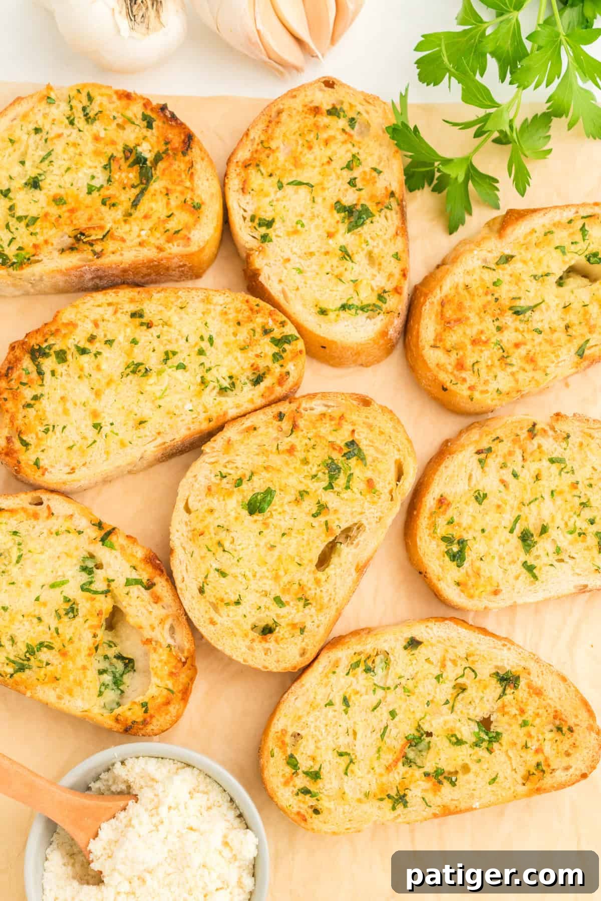 Golden Garlic Bread in Minutes 9 Slices of thick and crispy Texas toast style garlic bread, garnished with parsley, on parchment paper.