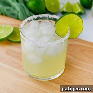 Classic margarita on the rocks with lime garnish and salted rim.