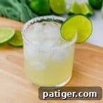Classic margarita on the rocks with lime garnish and salted rim.
