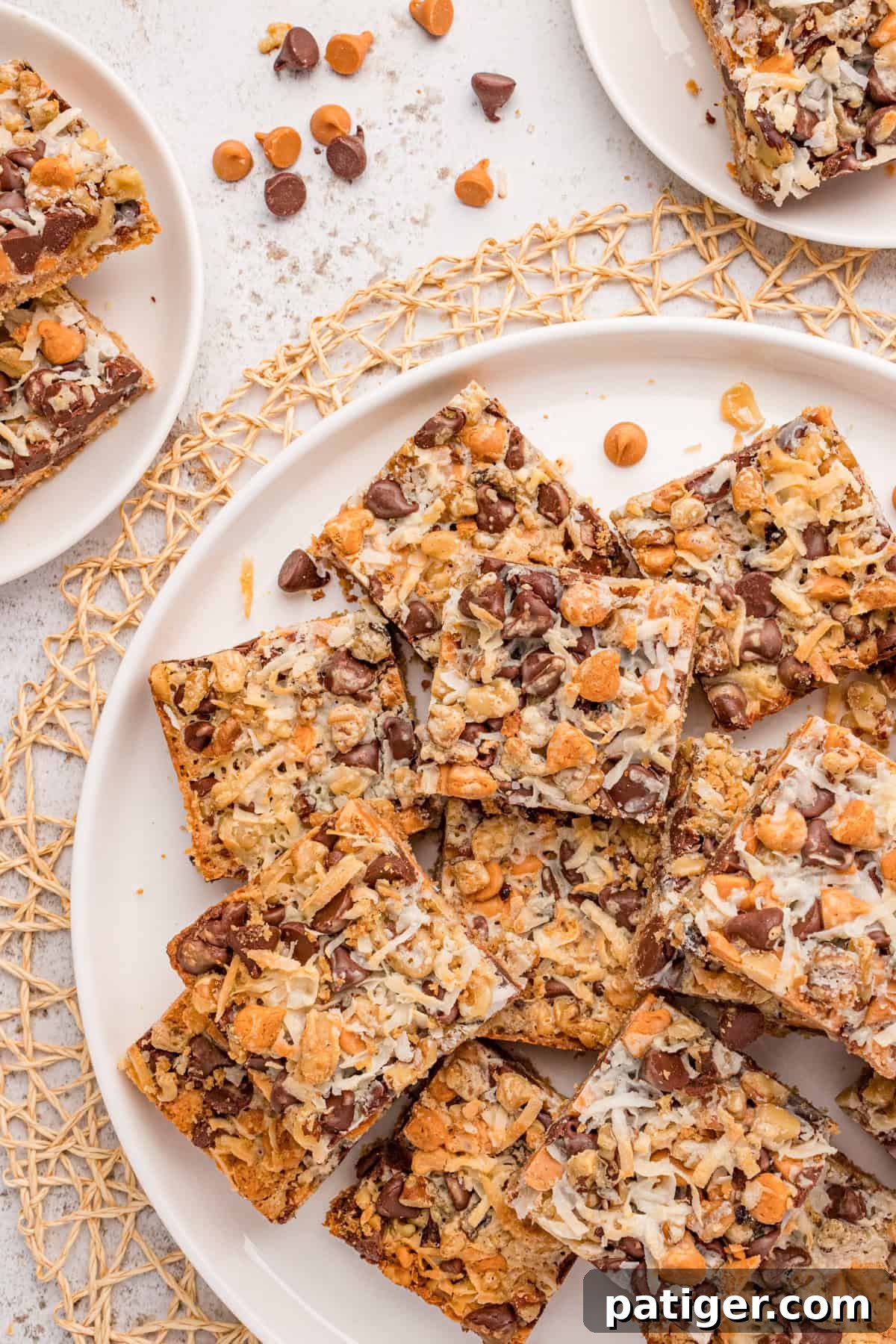Homemade 7 layer magic cookie bars piled on a large platter for serving.