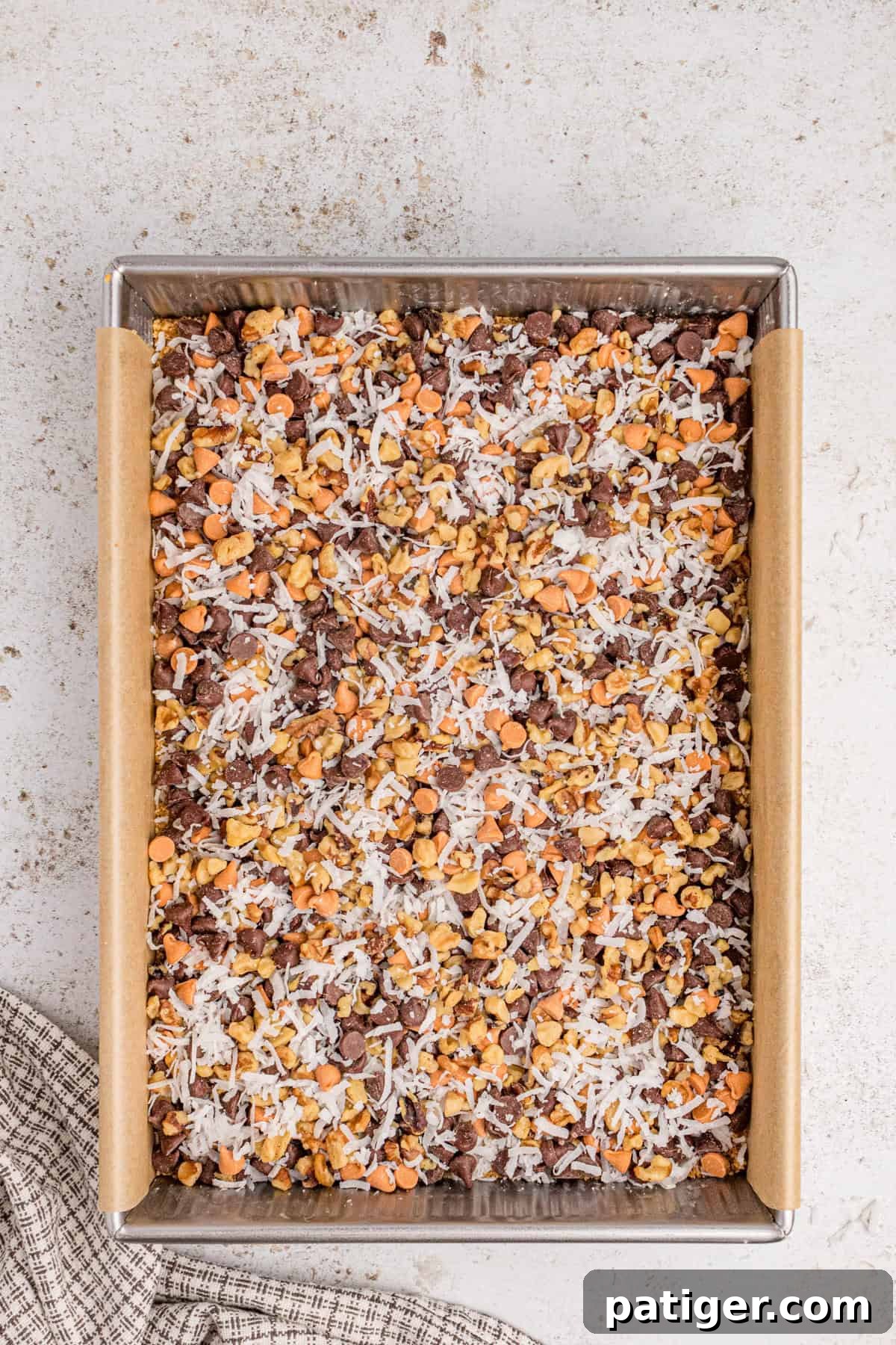 Chocolate chips, butterscotch chips, coconut, and chopped nuts added over graham cracker base.