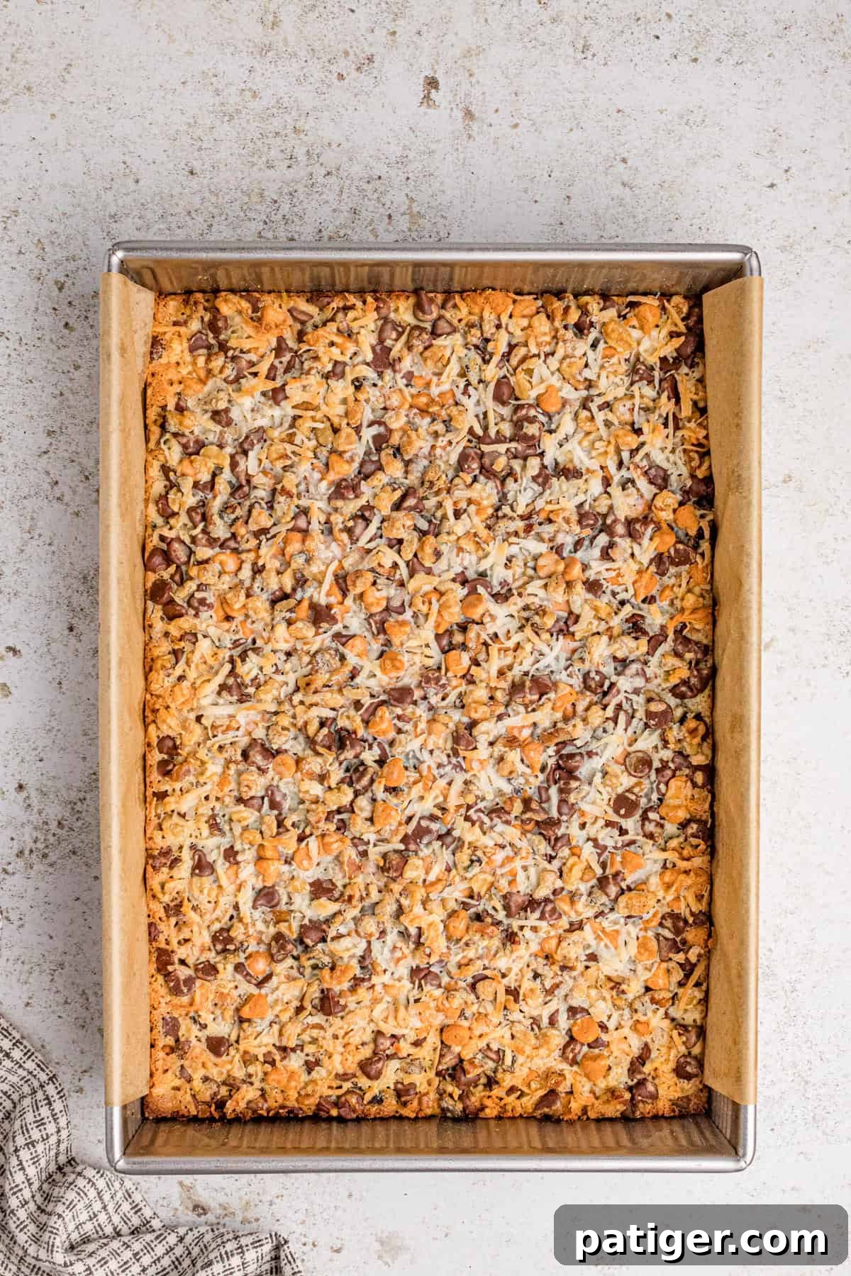 Baked 7 layer cookie bars with golden edges and toasted coconut. The sweetened condensed milk has been absorbed into the bars.