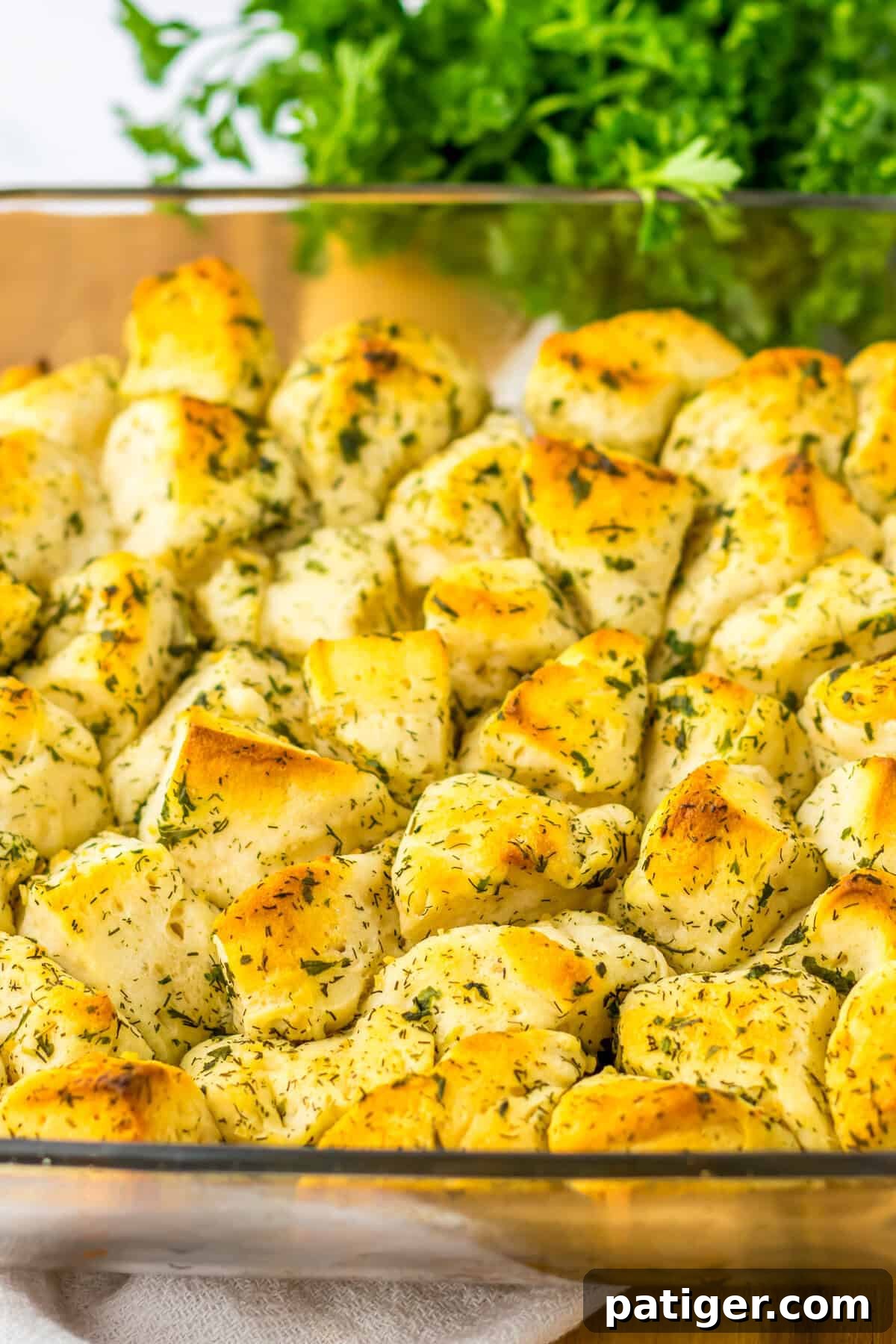 Aromatic Pull-Apart Herbed Biscuits 2 Savory monkey bread made in a square glass dish with biscuit dough, butter, and herbs, showcasing its golden brown crust.