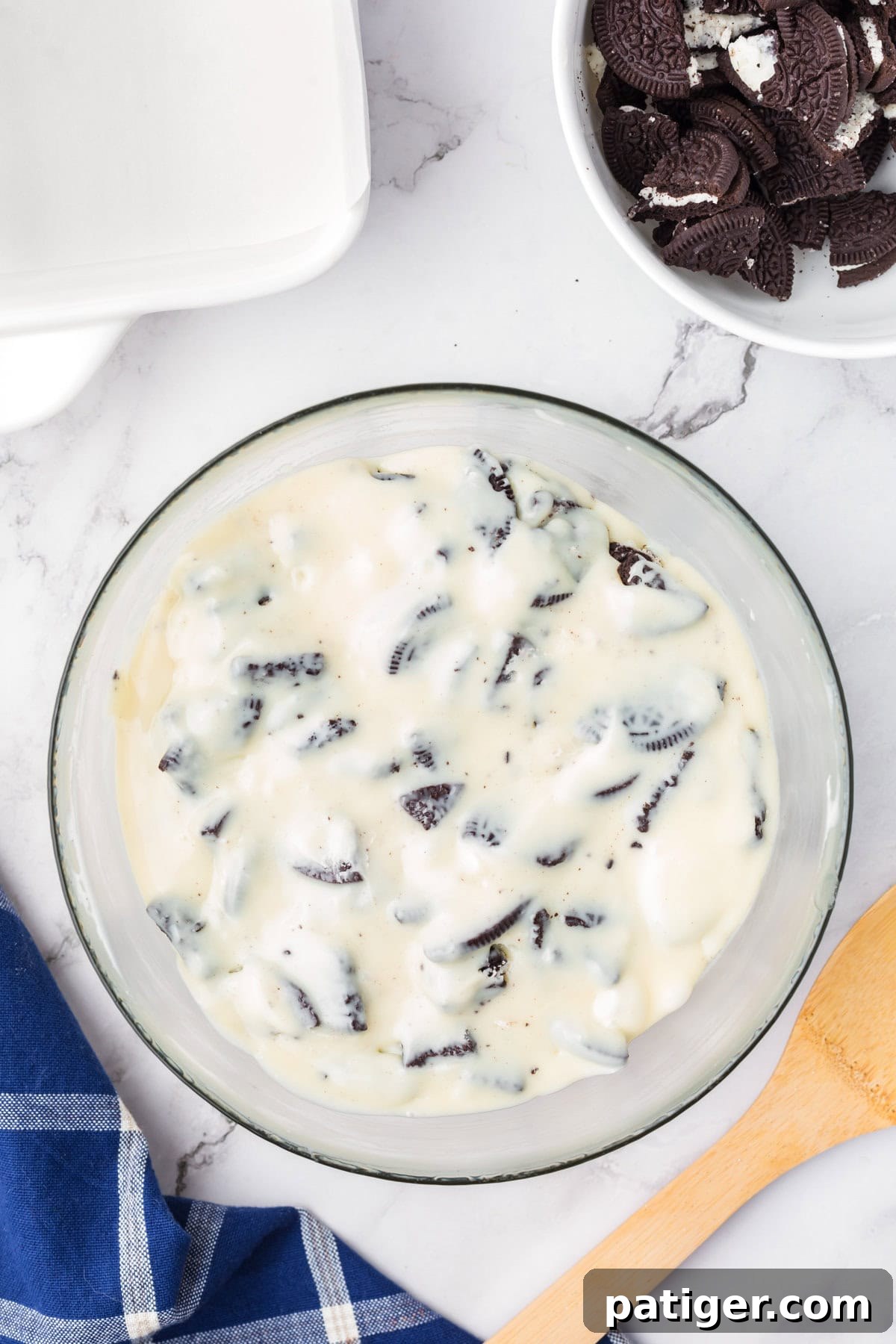 Super Simple 3-Ingredient Oreo Fudge 6 Glass bowl of oreo fudge mixture with chunks of oreo cookies.