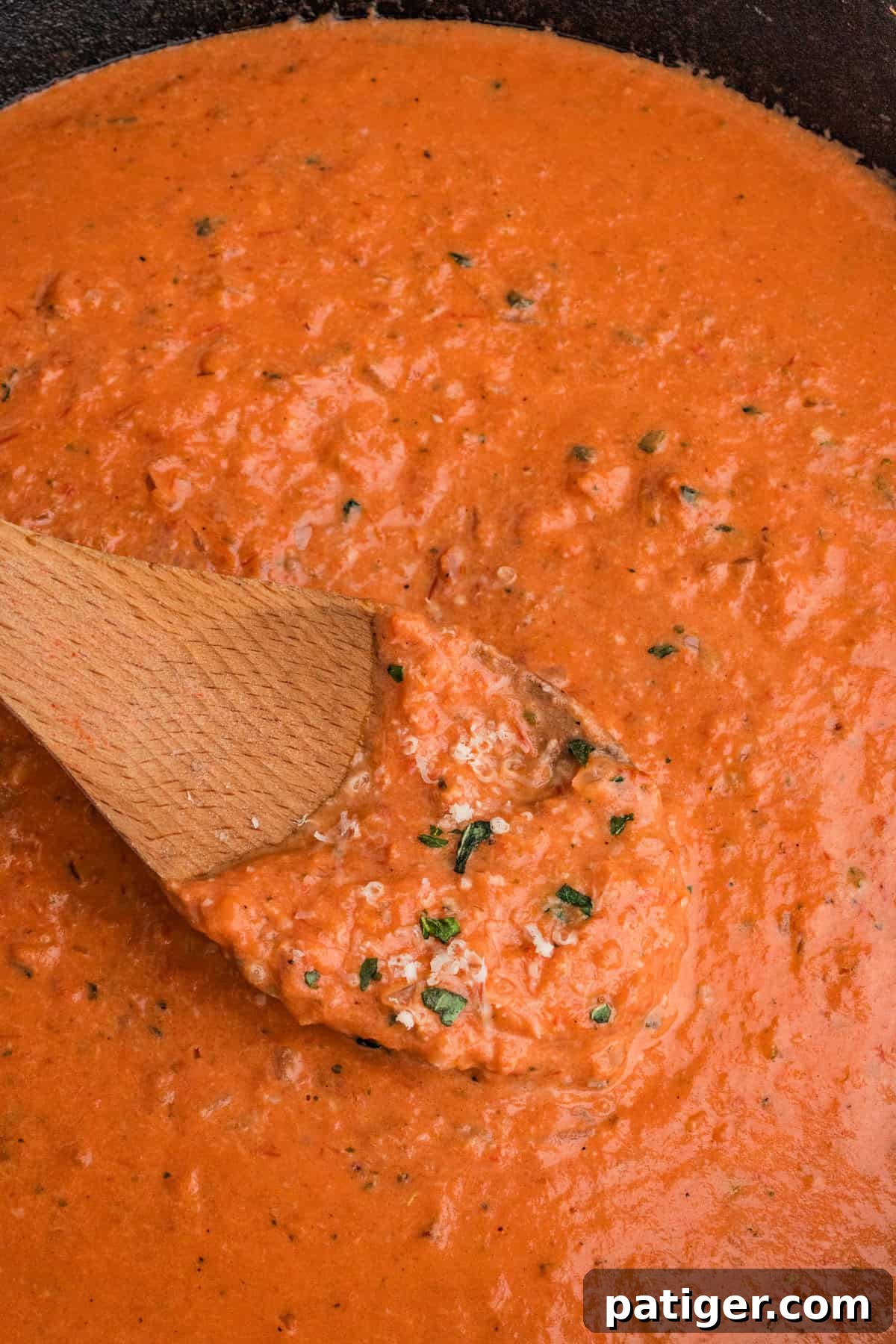Close-up of thick, creamy vodka sauce with visible prosciutto bits, highlighting its rich texture.