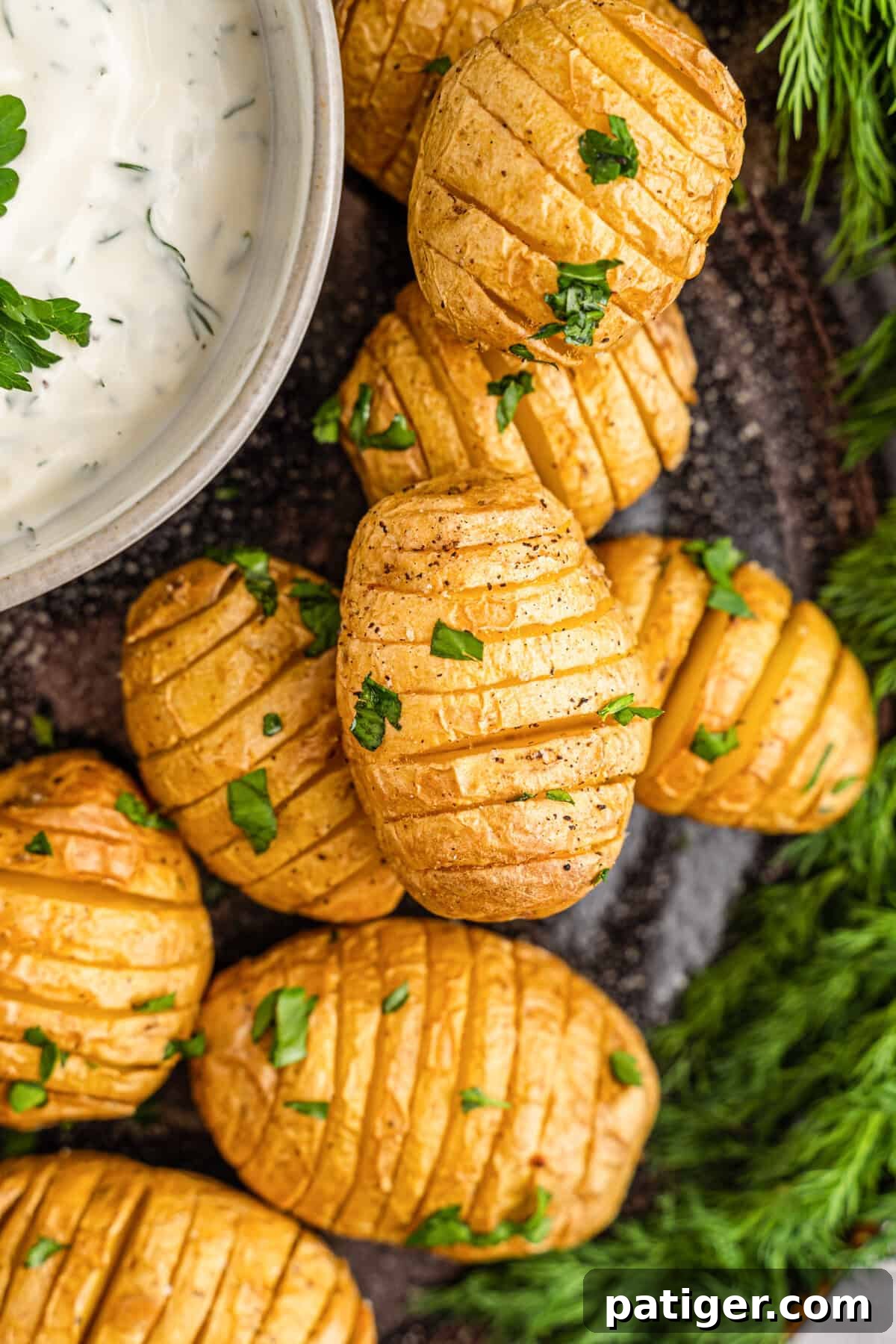 Crispy Mini Hasselback Potatoes served with a bowl of creamy homemade dill dip, garnished with fresh dill.