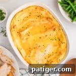 Party Potatoes with cream cheese surrounded by holiday meal including turkey, gravy, and green beans.