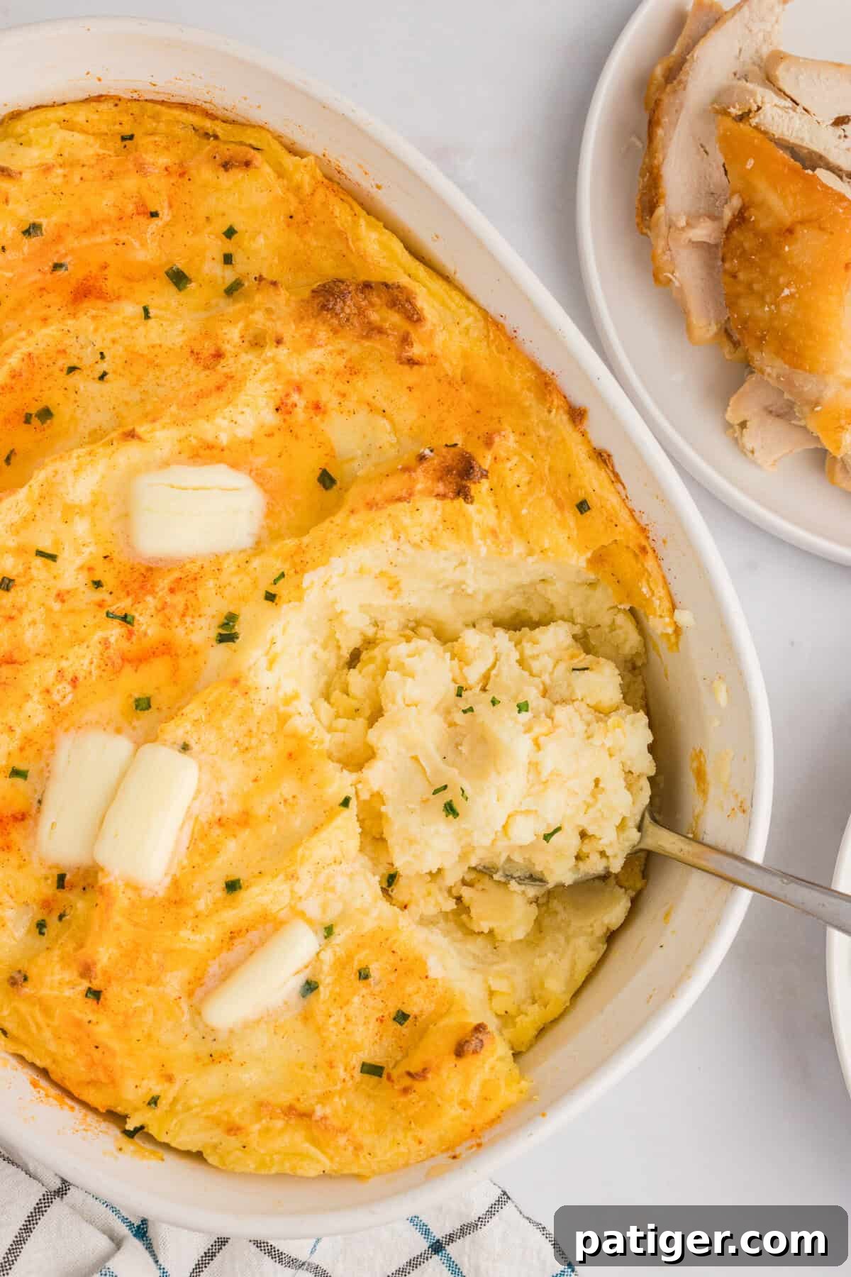 Spud-tacular Party Bites 3 Cream Cheese Baked Mashed Potatoes topped with paprika, butter, and chopped chives.