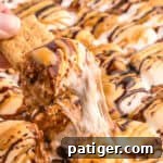 Graham cracker being dipped in chocolate peanut s'mores dip.