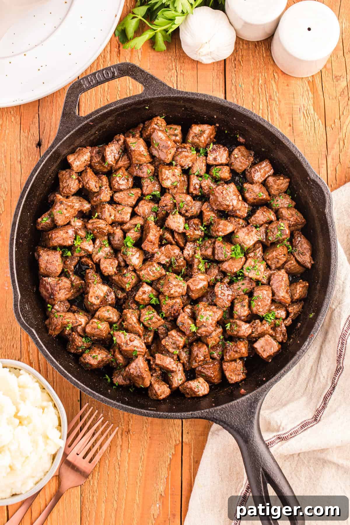 Golden Garlic Steak Bites 2 Garlic butter steak bites in cast iron skillet, ready to serve.