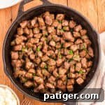 Cast iron skillet filled with garlic butter steak bites, ready to serve.