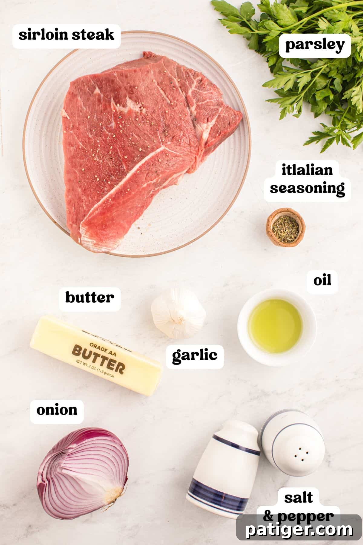 Golden Garlic Steak Bites 4 Ingredients for garlic butter steak bites, including raw steak, garlic, butter, parsley, and seasonings laid out on a countertop.