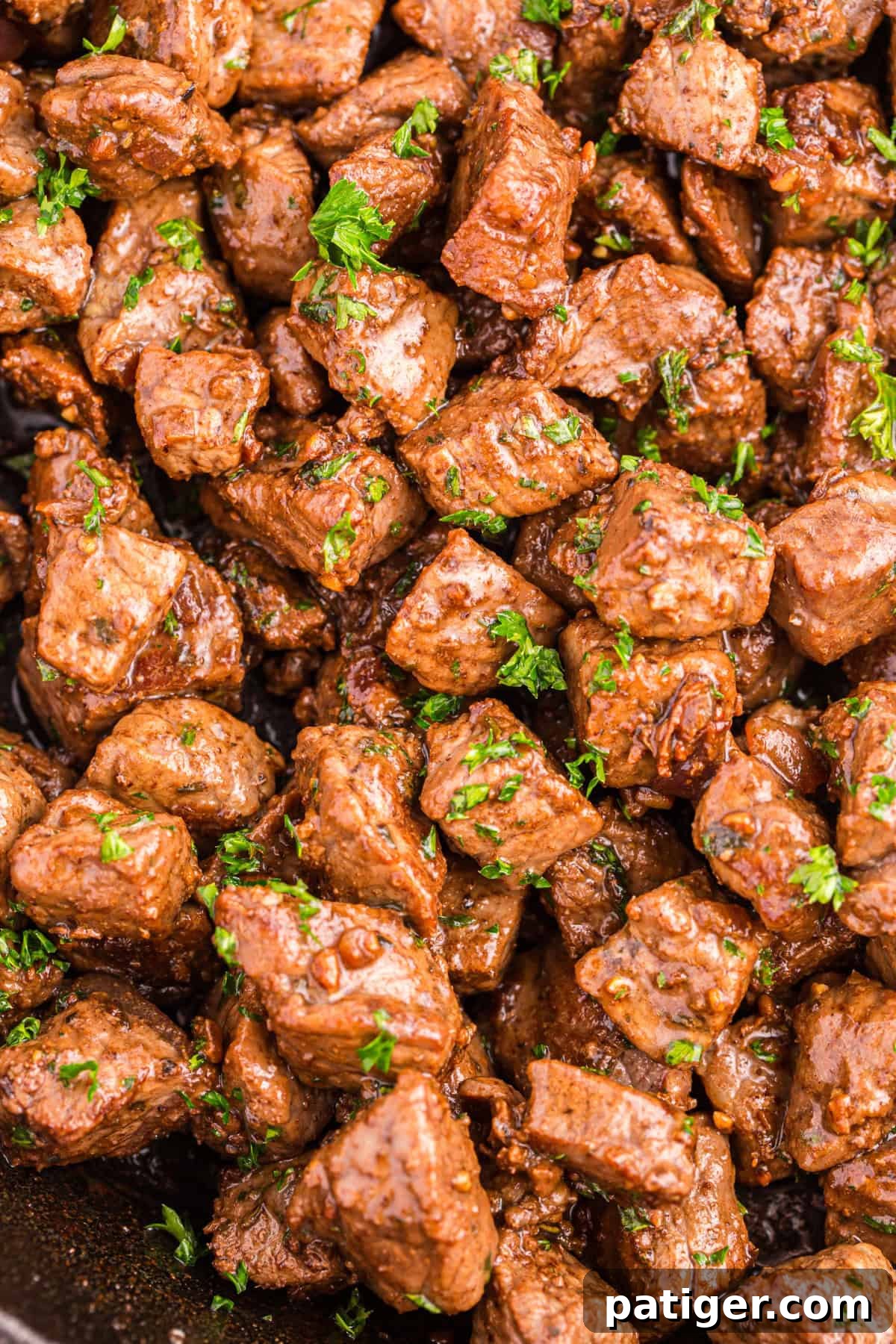 Golden Garlic Steak Bites 8 Overhead view of cooked garlic butter steak bites in a skillet.