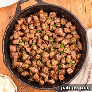 Cast iron skillet filled with garlic butter steak bites, ready to serve.
