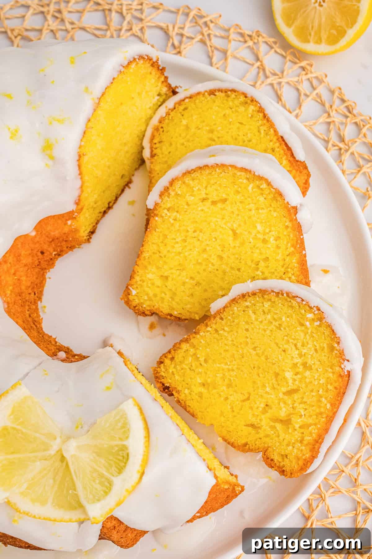 Glazed Lemon Bundt Cake on platter with some pieces sliced.
